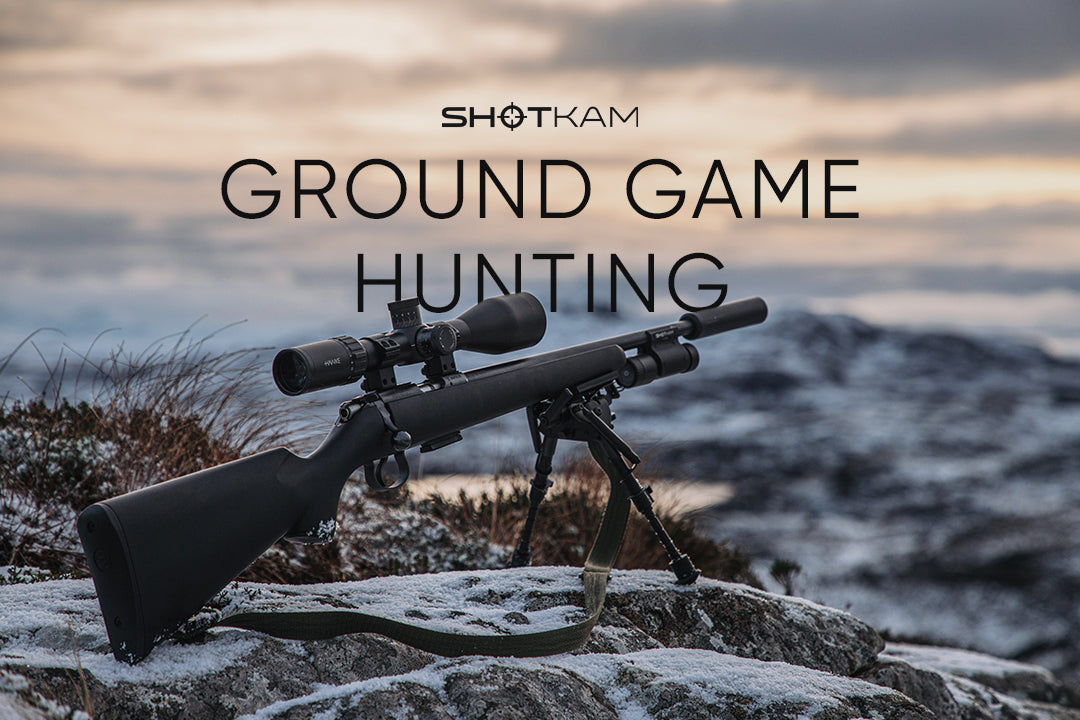 ShotKam blog thumbnail featuring a rifle with a mounted scope and bipod resting on rocky terrain with a snowy, mountainous background. The text reads 'Ground Game Hunting' with the ShotKam logo above.