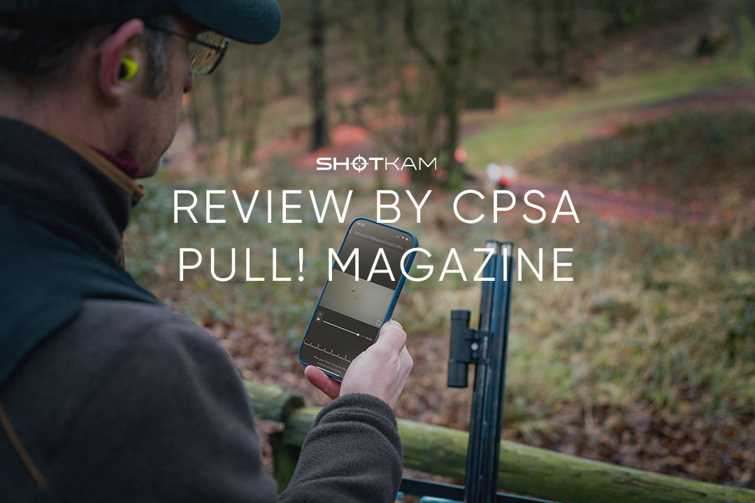 ShotKam blog image featuring a man outdoors holding a smartphone displaying a video. The text reads 'Review by CPSA Pull! Magazine,' with the ShotKam logo at the top. The background shows a wooded area.