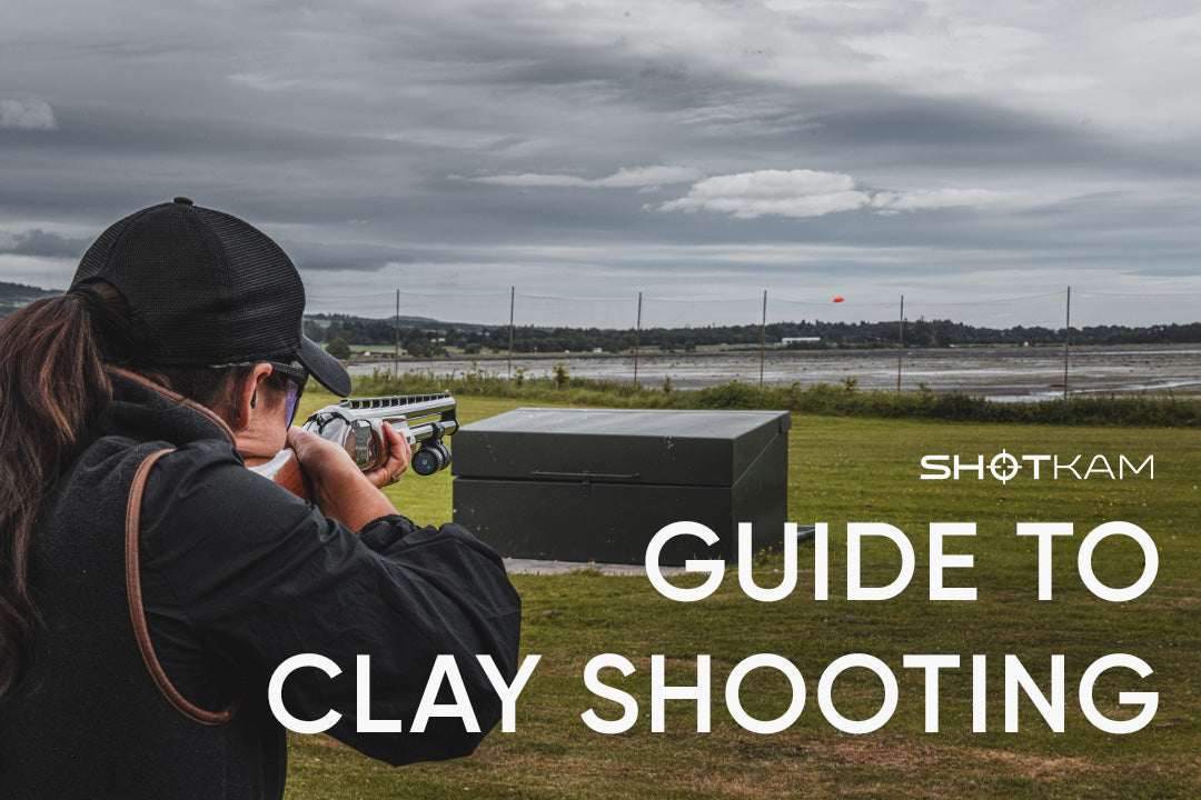 Woman aiming a shotgun with a ShotKam at an orange clay target