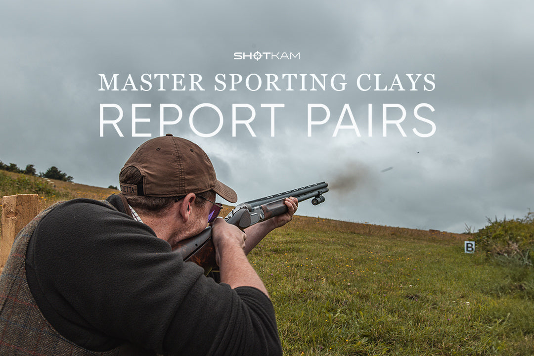 Clay shooter aiming at report pairs with ShotKam mounted on shotgun during cloudy day on open field