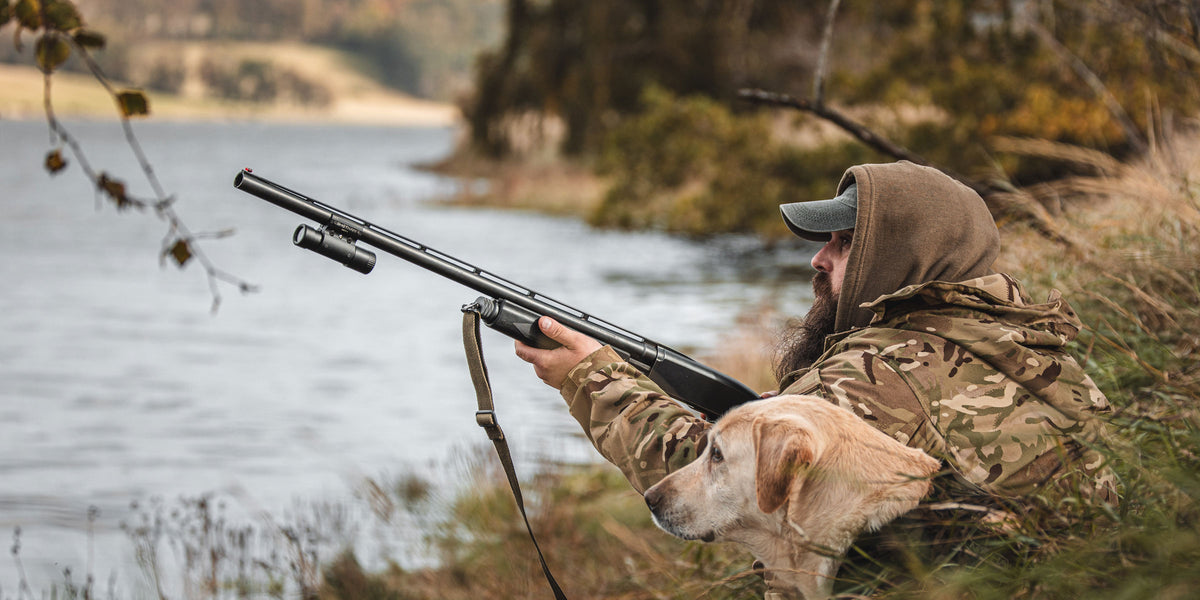 A hunter using the ShotKam Gen 4 on his pump shotgun to record 4K video capturing high quality hunting footage accompanied by his dog