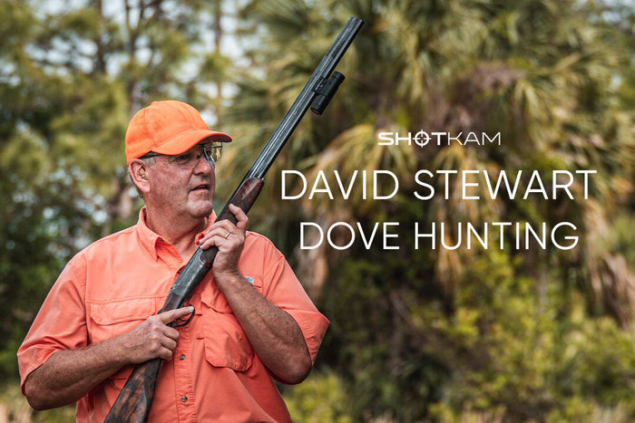Man in orange hunting gear holding shotgun with ShotKam camera attached, titled David Stewart Dove Hunting.