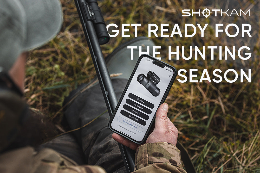 Hunter using the ShotKam app on a smartphone while preparing for hunting season.