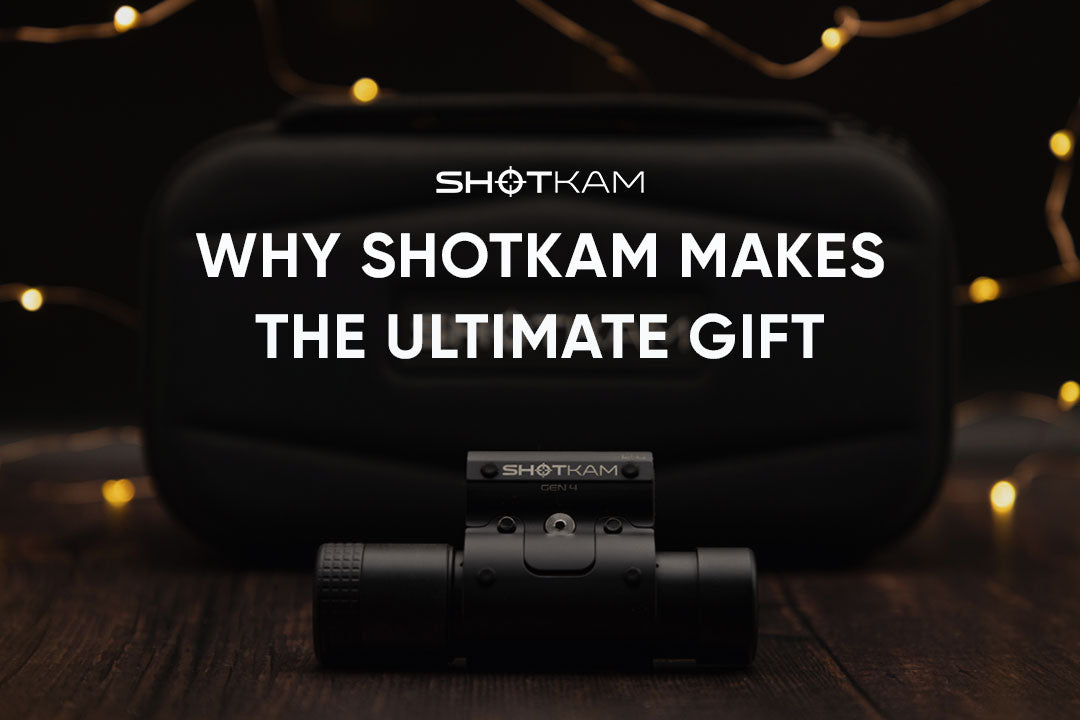 ShotKam Gen 4 camera displayed in front of its carry case with warm holiday string lights in the background.