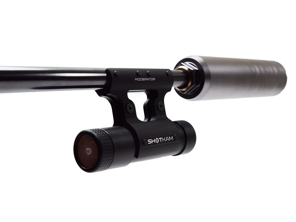 High-precision ShotKam moderator attached to a shotgun barrel, enhancing accuracy for hunters and shooting sports enthusiasts. This sleek black shooting accessory improves performance in hunting and shooting sports. Keywords: ShotKam moderator, shotgun barrel accessory, precision shooting gear, hunting equipment, shooting sports enhancement, advanced shooting accessories, improve shooting accuracy, sleek black design.